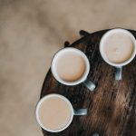 flat lay photography of eight coffee latte in mugs on round table