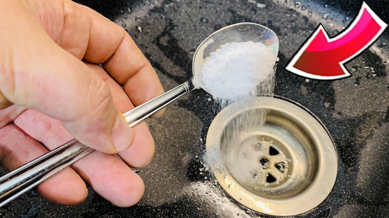 Abfluss reinigen mit Hausmitteln wie Natron und Essig in einer modernen Küche