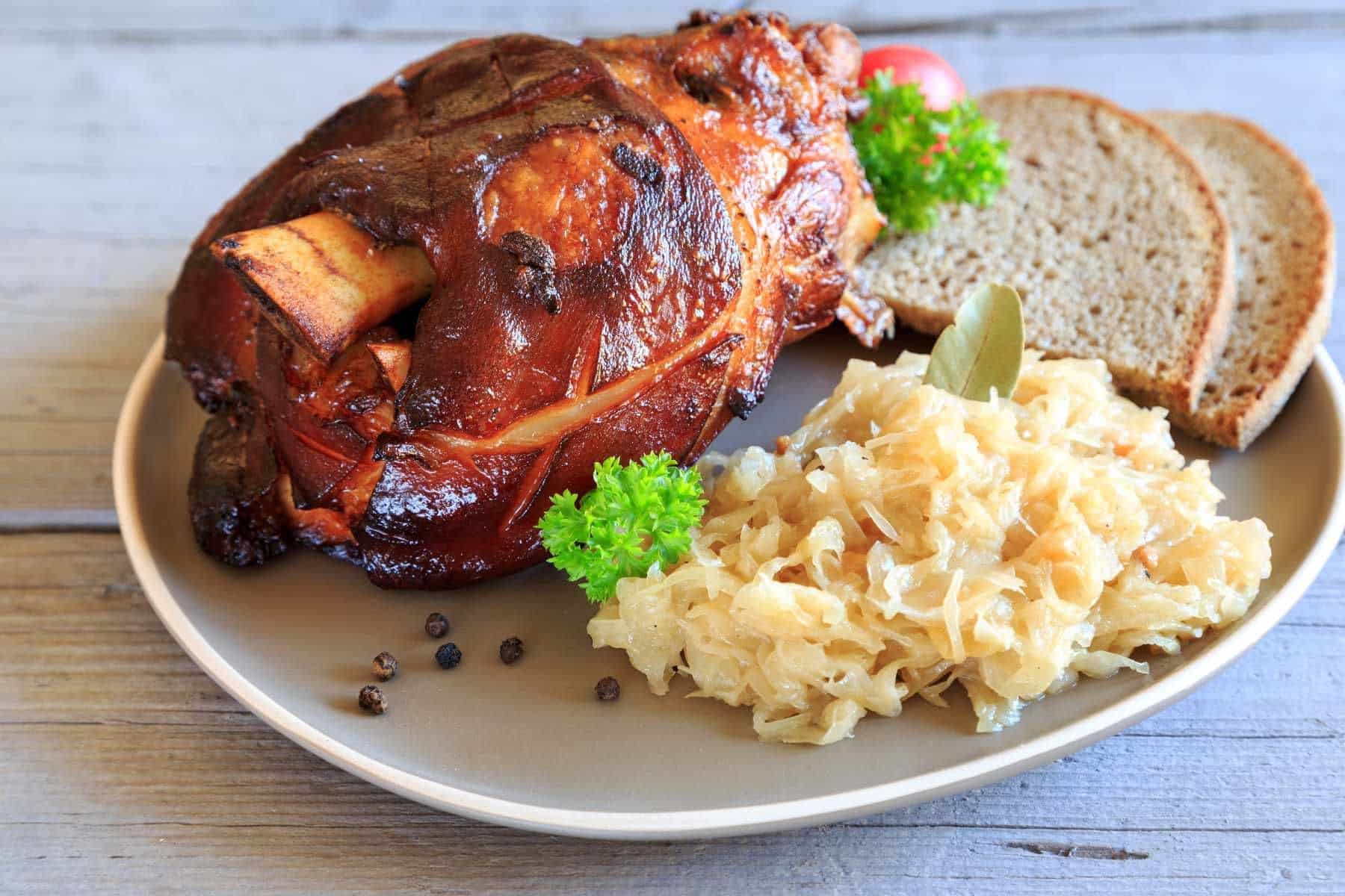 Ein leckeres Sonntagsessen. Wir geben Ihnen das Rezept, Sie kochen. Gebackene Schweinshaxe auf Sauerkraut
